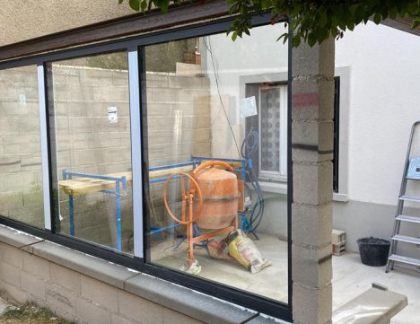 Chantier de véranda : contrechamp de l'installation des fenêtres